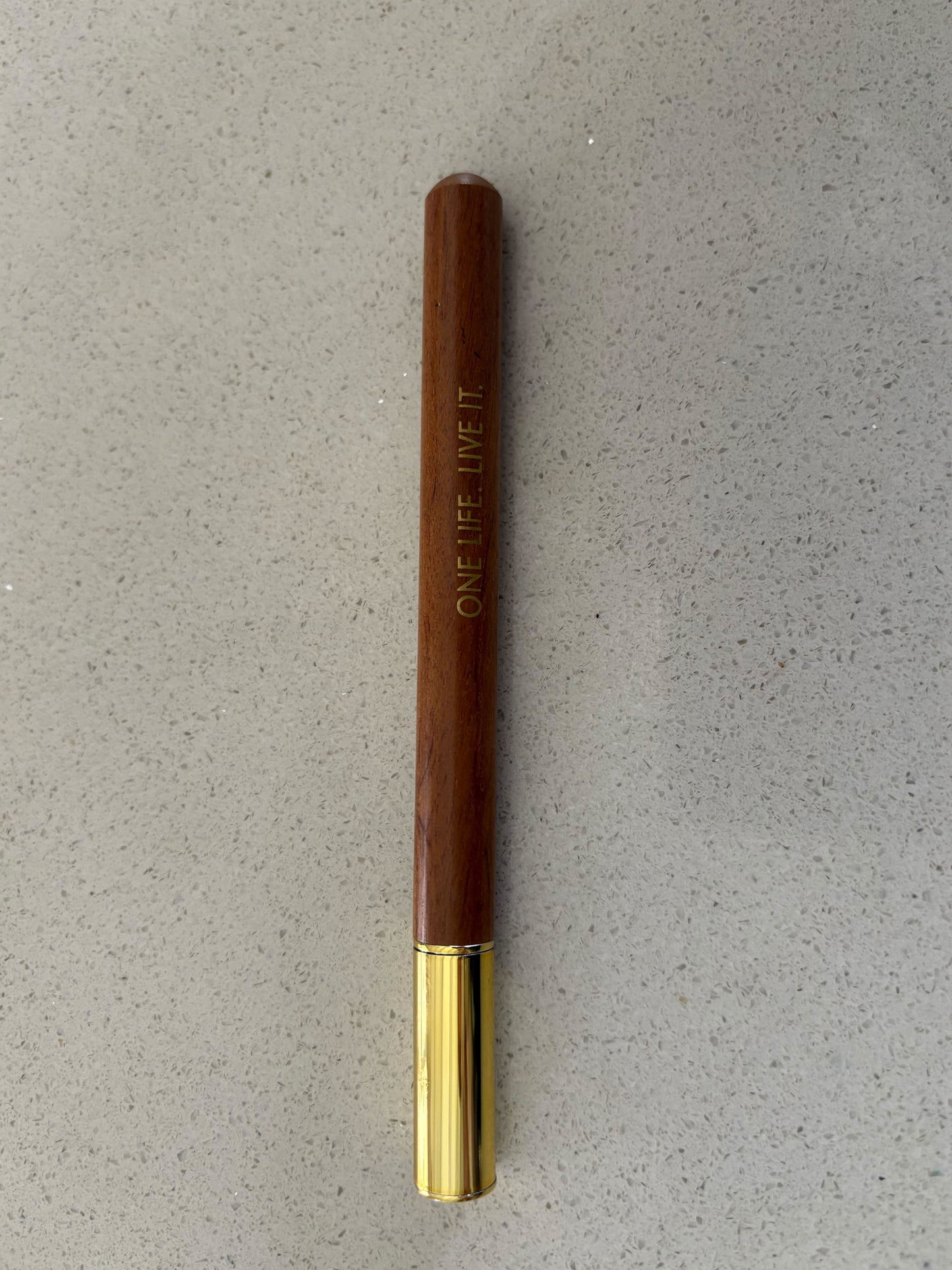Wooden pen with brass accents, black ink, one life live it